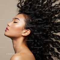 Profile of woman with flowing curly hair and closed eyes