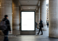 Blank illuminated billboard in urban colonnade walkway