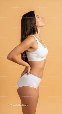 Young Woman in White Sportswear Showing Confident Posture Against Beige Background