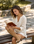Young woman enjoying a serene moment reading outdoors