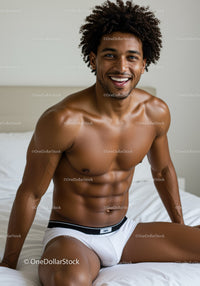 Smiling man with muscular build sitting on bed in white underwear