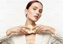 Elegant Woman with Red Hair and Fresh Pear in Studio Portrait