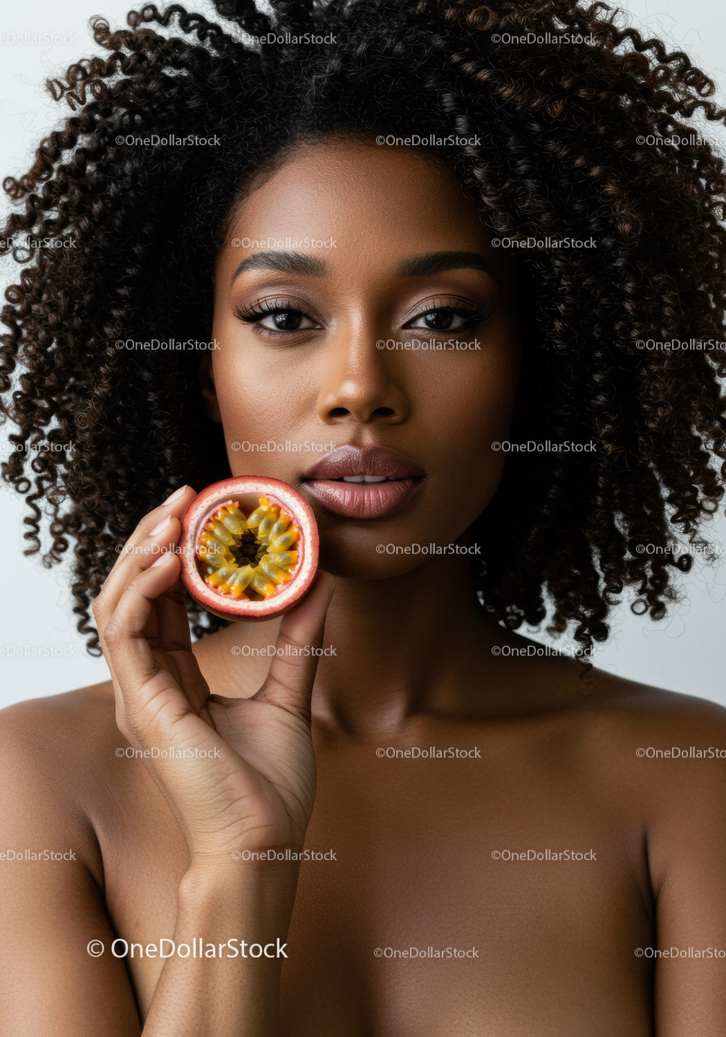 Portrait of a Beautiful Woman with Curly Hair Holding Passion Fruit