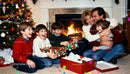 Joyful family opening Christmas gifts by fireplace