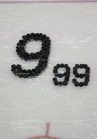 Nineteen written with hockey pucks on ice rink