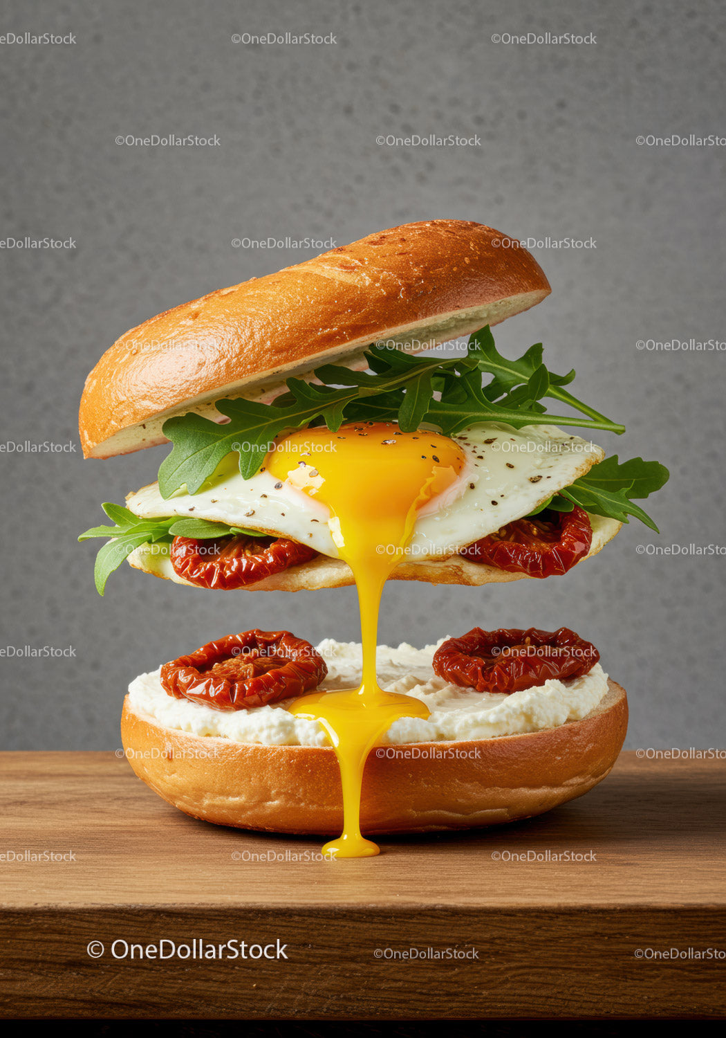 Bagel sandwich with runny egg yolk and sun-dried tomatoes