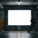 Blurred pedestrian walking past empty illuminated billboard