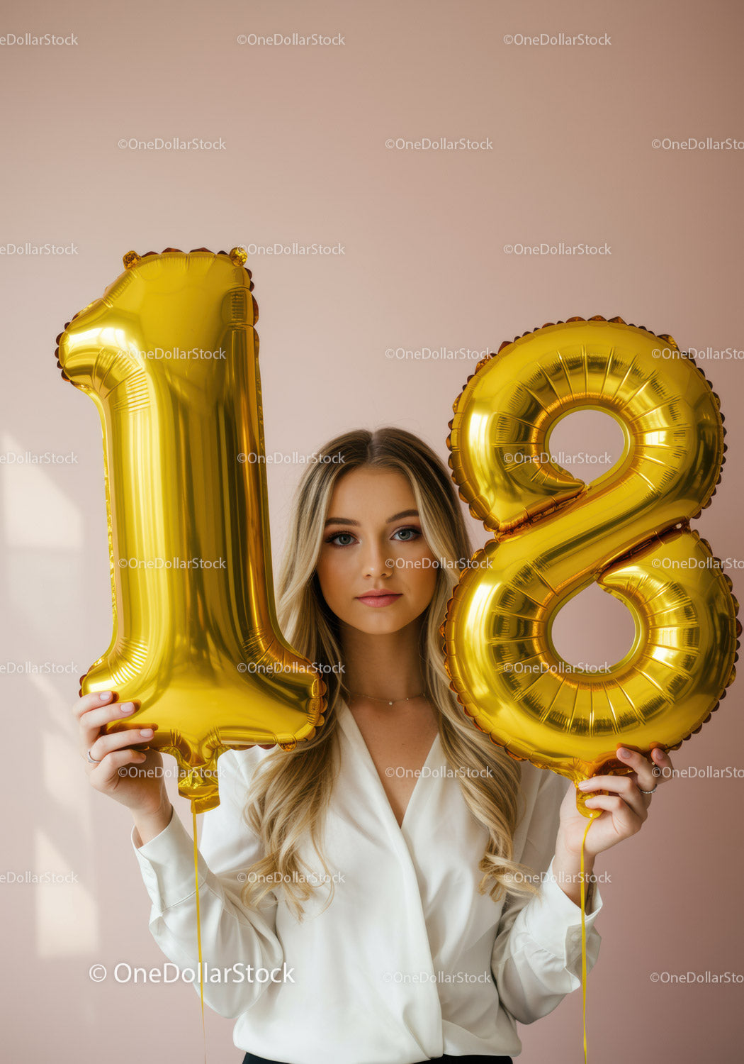 Young woman celebrating 18th birthday with gold balloons