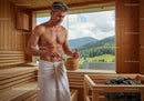 Man in Wooden Sauna with Mountain View and Rocky Sauna Heater