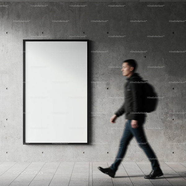 Young man walking past blank poster on concrete wall JPG Mockup Image