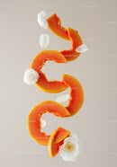 Sliced papaya with delicate white camellia flowers