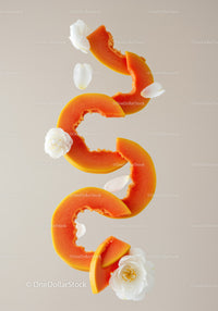 Sliced papaya with delicate white camellia flowers