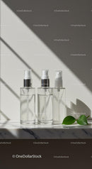 Clear Cosmetic Spray Bottles on Marble Surface with Leaf