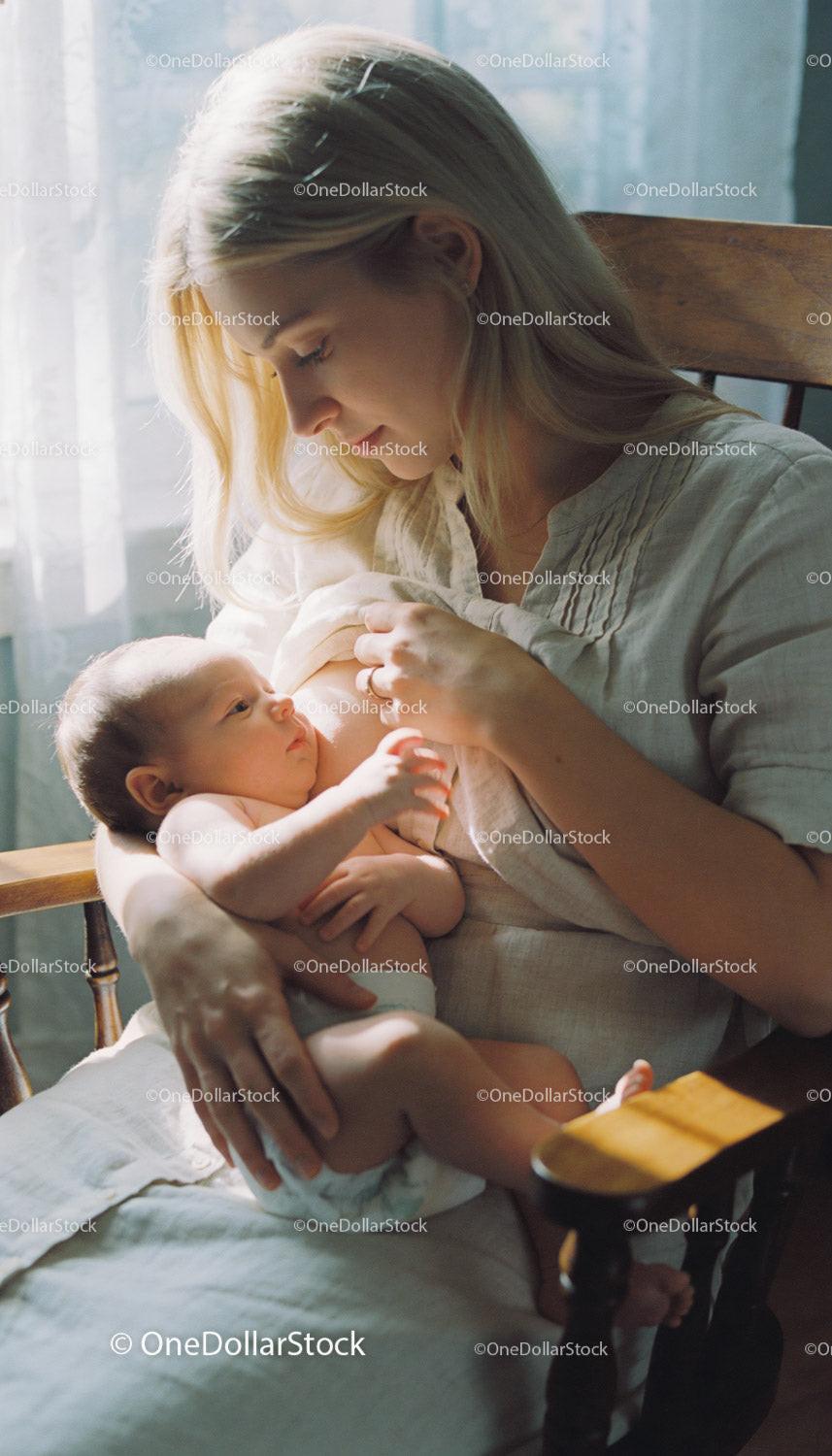 Mother Tenderly Breastfeeding Her Newborn Baby at Home
