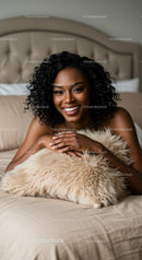 Smiling woman relaxing with cozy fluffy pillow on bed