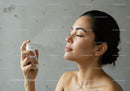 Young Woman Spraying Skincare Product for Fresh and Healthy Skin