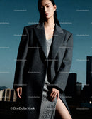 Confident woman in oversized gray coat with city view