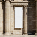 Blank white banner hanging on classical stone columns