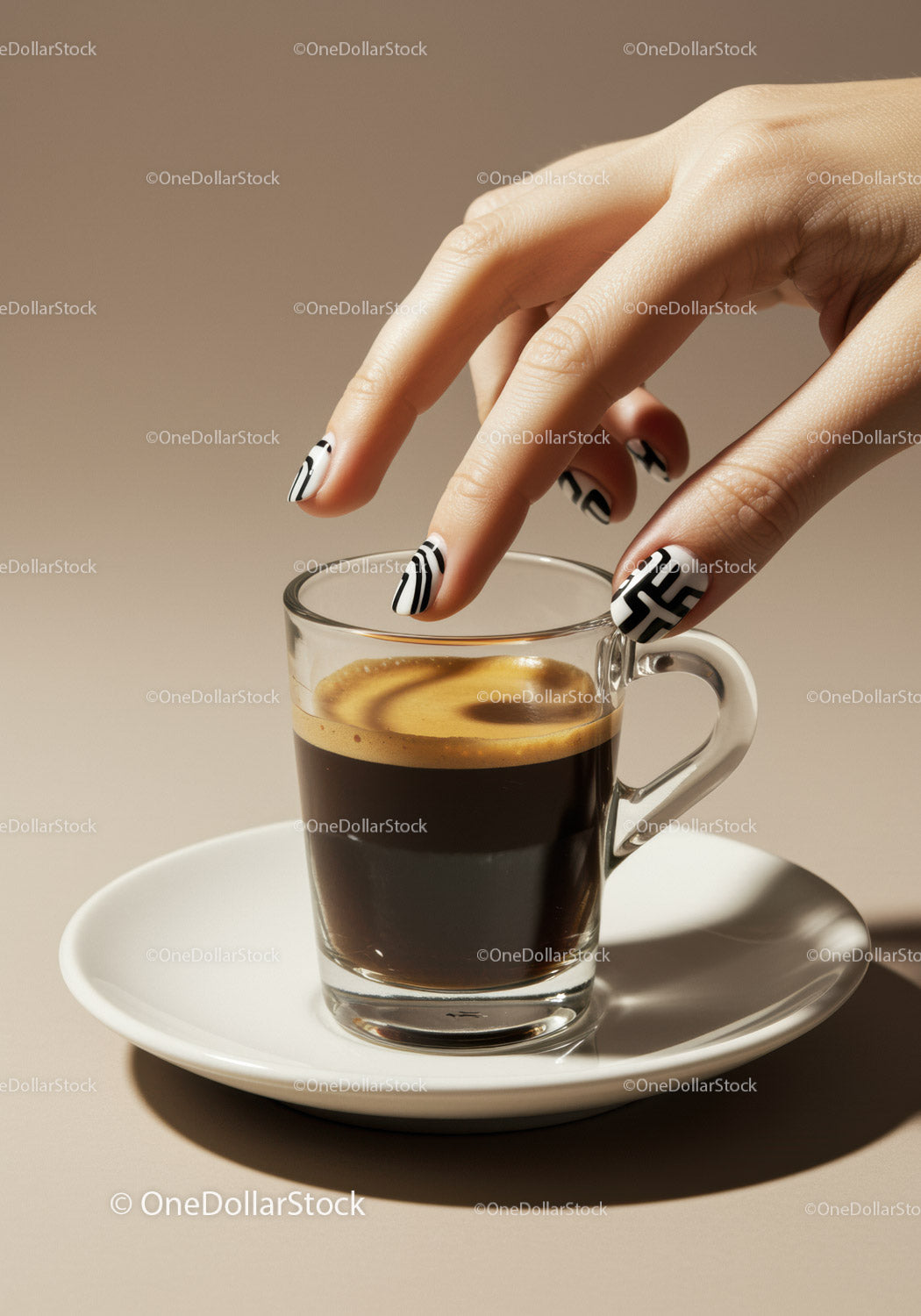 Ręka kobiety sięgająca po espresso z artystycznymi paznokciami