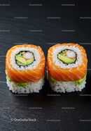 Salmon and avocado sushi rolls on dark slate surface