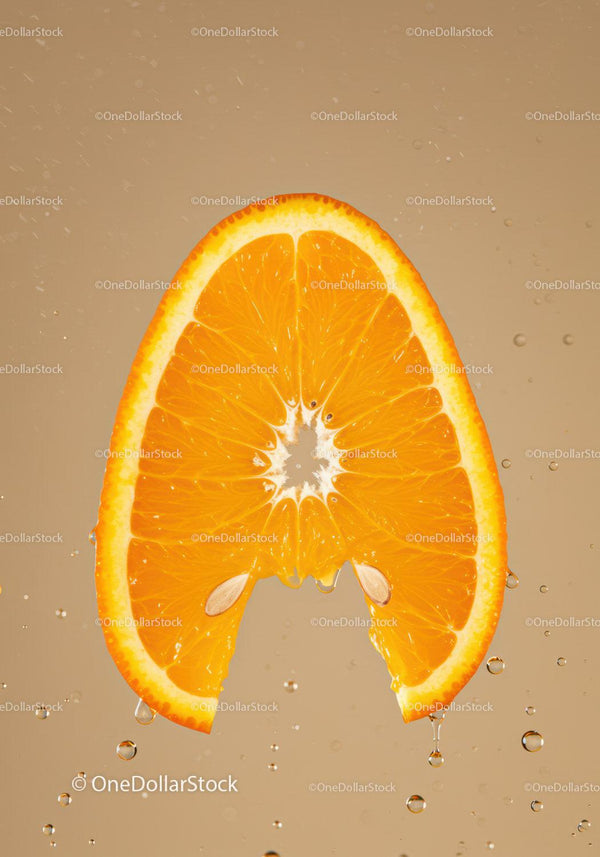 Fresh orange slice dripping with juice in water