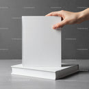 Hand Holding Blank White Book on Gray Surface