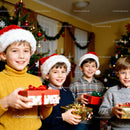 Smiling children in Santa hats holding Christmas gifts