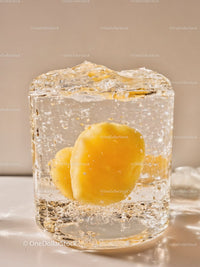 Yellow apricot encased in clear ice cube