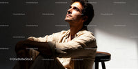 Thoughtful man sitting solo in warm natural light