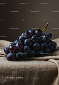 Fresh dark grapes on rustic fabric background