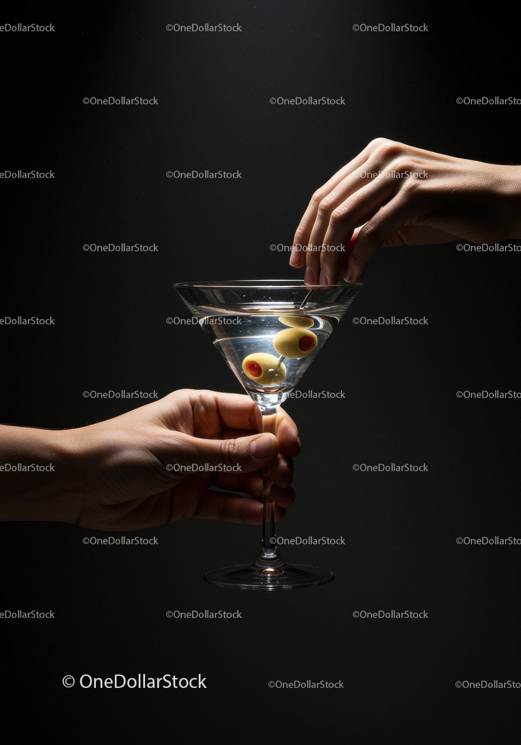 Hand serving martini with olives on dark background