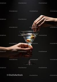 Hand serving martini with olives on dark background