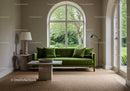 Modern living room with green sofa and large window