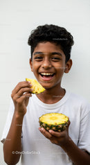 Joyful Child Enjoying Fresh Pineapple with Bright Smile