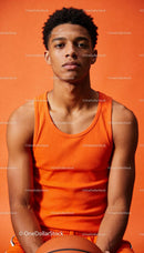 Focused Young Athlete with Basketball Against Orange Wall