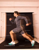 Male athlete sprinting indoors with dynamic motion blur
