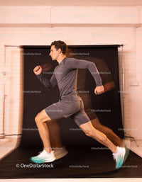 Male athlete sprinting indoors with dynamic motion blur