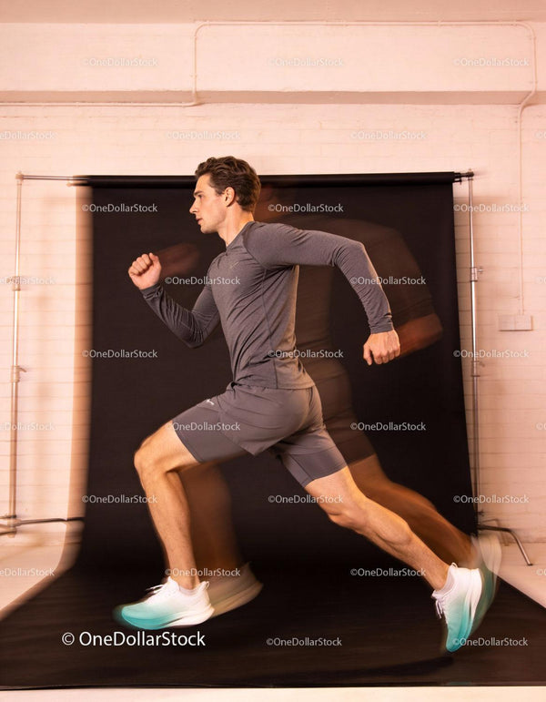 Male athlete sprinting indoors with dynamic motion blur