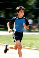 Focused boy running outdoors on a sunny day