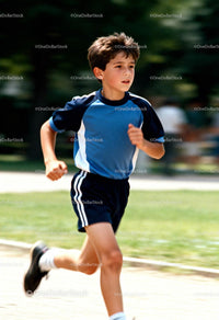 Focused boy running outdoors on a sunny day