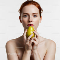 Elegant Woman with Freckles Holding a Pear in Studio Portrait