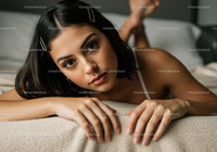 Close-up of Young Woman with Dark Hair Relaxing on Cozy Beige Blanket