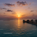 Sunset over the Ocean with Overwater Bavilions and Scenic Sky