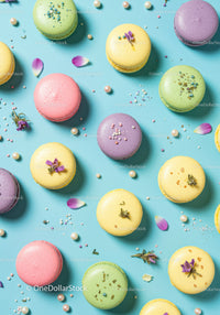 Colorful macarons decorated with flower petals on blue