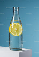 Clear Glass Bottle with Lemon Slice in Sparkling Water on Blue Background