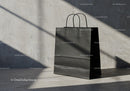 Matte black paper shopping bag with natural shadows