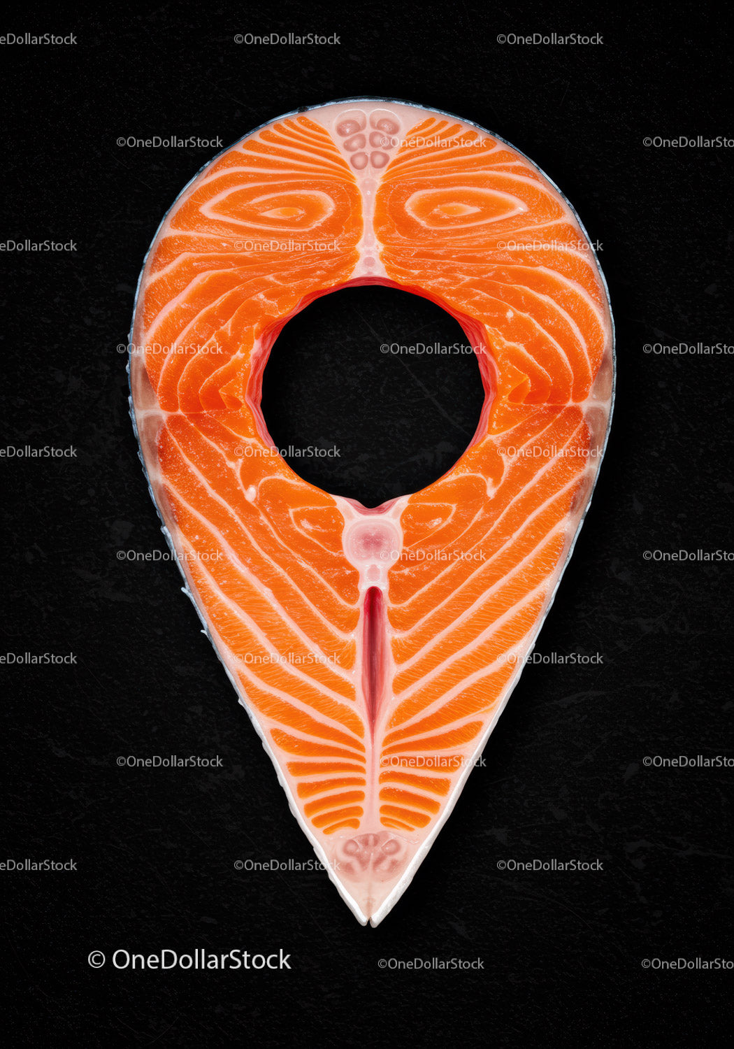 Fresh salmon steak slice on black textured surface