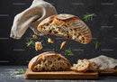 Rustic sourdough bread with flying crumbs and herbs