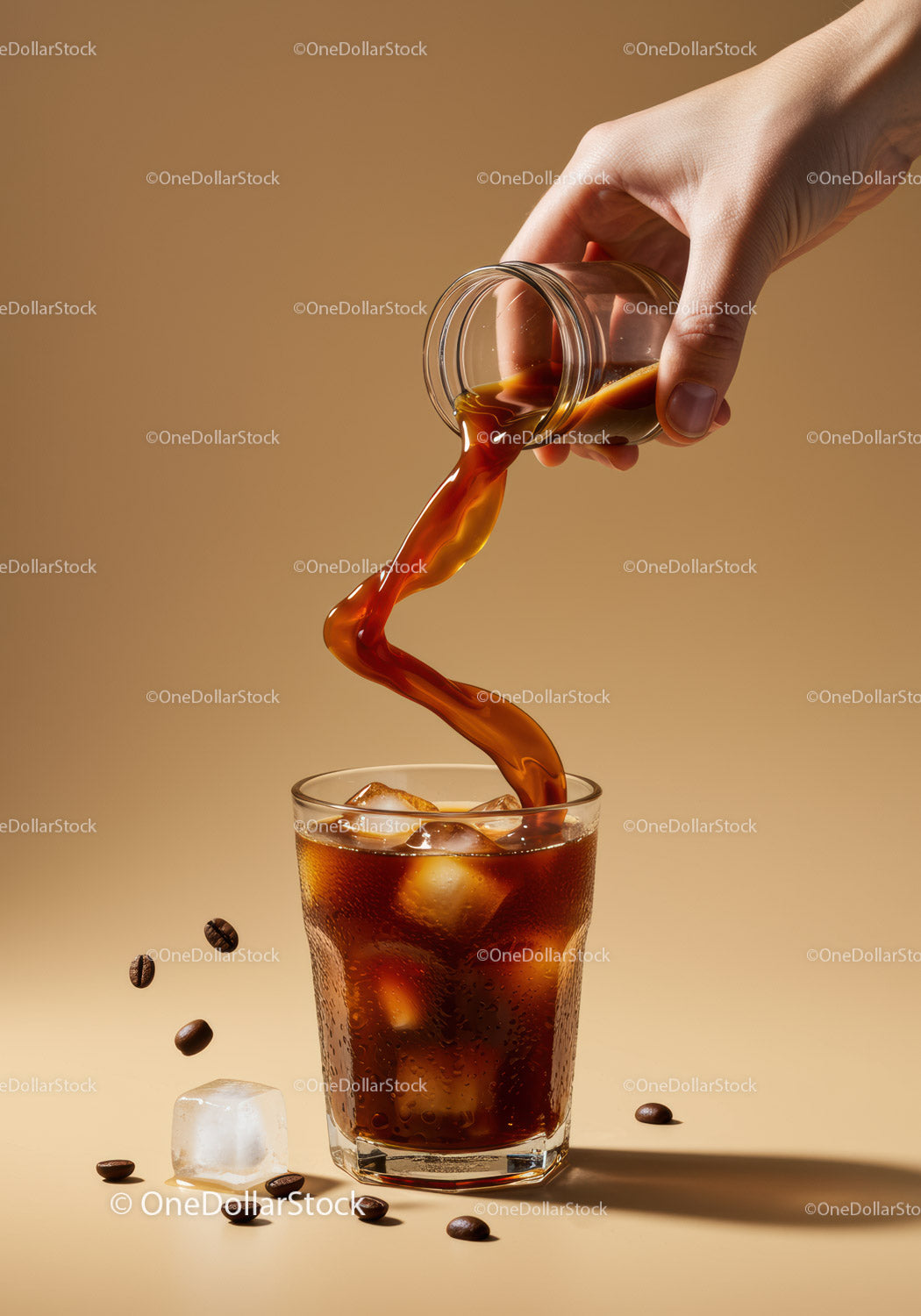 Pouring Iced Coffee Over Glass with Coffee Beans