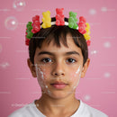 Child with Gummy Bear Crown and Face Paint on Pink Background